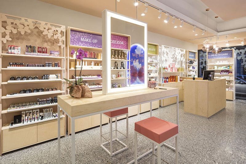 Bioprofumeria in stile nordico con make-up station centrale e arredi in legno chiaro