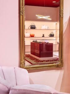 negozio borse e accessori con arredo in stile moderno e elegante arricchito da alcuni dettagli classici come uno specchio vintage a parete