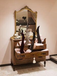 cassettiera in legno vintage con specchio riutilizzata come mobile espositore per negozio di intimo