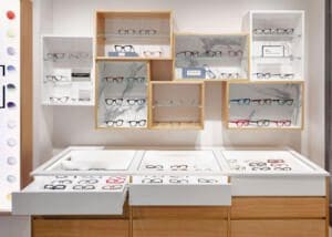 Espositori per ottico con vetrinette in legno in stile geometrico, progettati per valorizzare diversi brand di occhiali, combinando eleganza e funzionalità