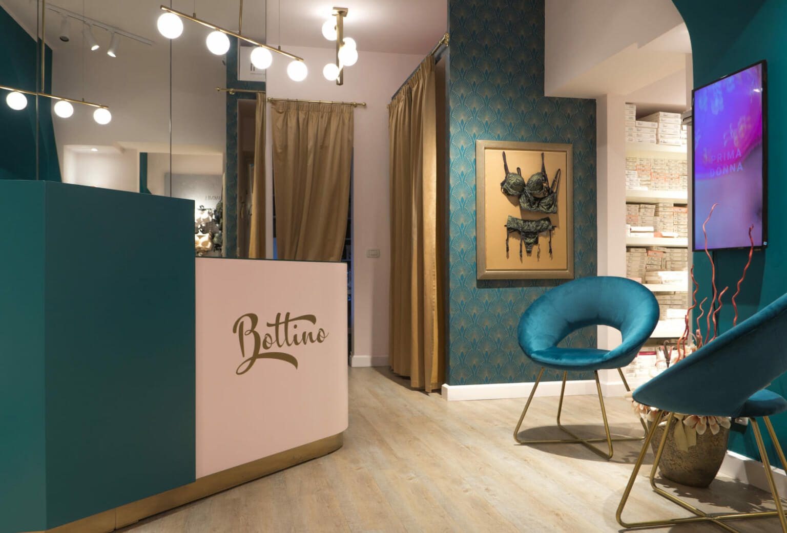 Restyling di un negozio di intimo con colori raffinati come verde petrolio e rosa pallido, in un’atmosfera elegante ispirata allo stile art-decò anni '30